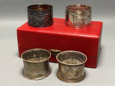 two silver cups and a red box on a white surface