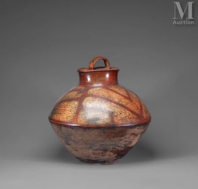 un vase marron posé sur une table près d'un mur gris