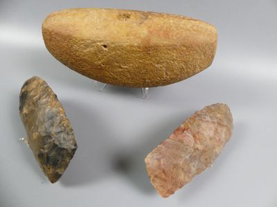 three different types of stone tools displayed on a white surface