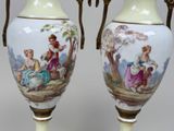 pair of vases with painted scenes on them sitting on a table