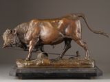 bronze statue of a bull on a wooden base with a rope