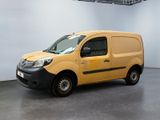 La camionnette jaune est garée dans une grande pièce aux murs blancs.