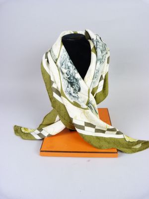 a green and white scarf on top of an orange box