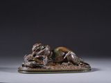 une statue en bronze représentant un chien couché sur le dos