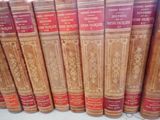 several old books are lined up in a row on a shelf