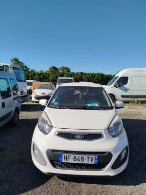 the white car is parked in the parking lot next to other cars