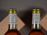 two bottles of whiskey sitting next to each other on a table
