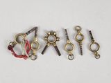 plusieurs types différents de crochets et de chaînes métalliques sur une surface blanche