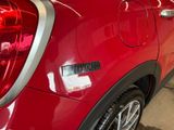 a close up of a red car with a sticker on the back of it