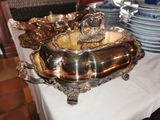 un plateau en argent posé sur une table où se trouvent des assiettes et des bols