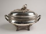 un plat ancien en argent orné d'un oiseau sur le dessus