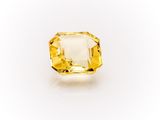 a yellow sapphire stone on a white background