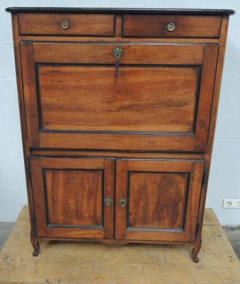une vieille armoire en bois posée sur un bloc de bois