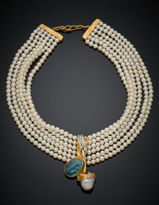 un collier de perles à trois rangs orné d'une pierre bleue et d'un fermoir en or