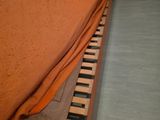 a bed with a wooden slatt and a pillow on top of it