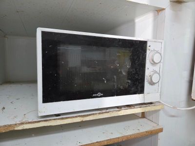un micro-ondes posé sur une étagère dans une pièce