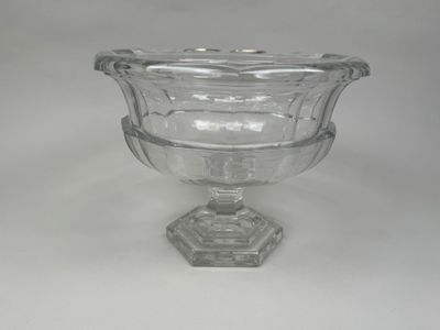 a glass vase with a glass base on a white surface
