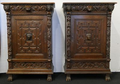 paire d'armoires anciennes en bois sculpté, ornées d'une tête de lion sur la porte