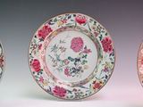 three plates with designs of flowers and birds on them on a white surface