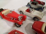 plusieurs petites voitures sont alignées sur une surface blanche