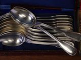 a lot of silver spoons and spoons in a box