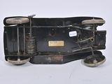 a small black toy car with wheels on a white surface