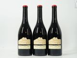 trois bouteilles de vin sont posées sur une surface blanche