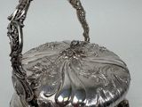 an antique silver plated basket with handles and handles on a table