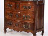 une commode en bois surmontée d'un plateau en marbre
