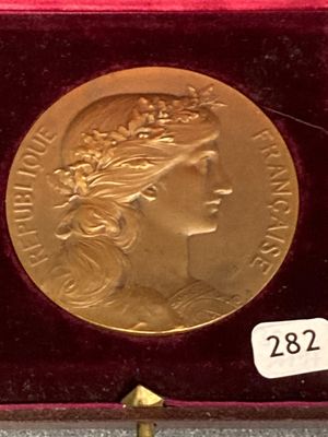 une médaille d'or dans un écrin en velours muni d'une étiquette