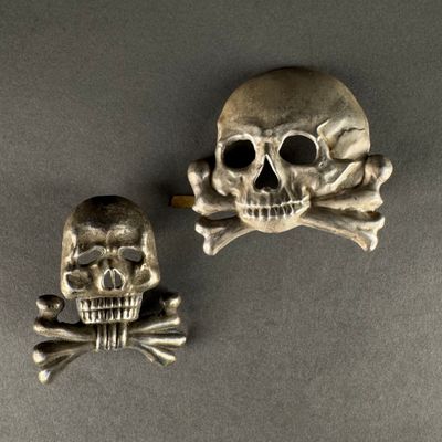 skull and crossbone broochs on a gray surface