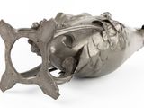 a metal object with a fish on it on a white surface