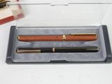 a pen and a ballpoint pen sitting in a box