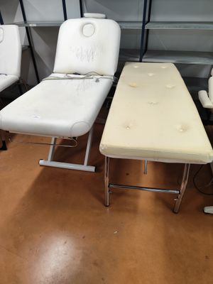 trois chaises blanches et une table dans une pièce