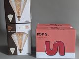 two boxes of light bulbs sitting next to each other on a table