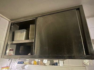 a stainless steel cabinet above a sink in a kitchen