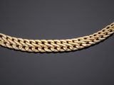 a gold chain necklace with a clasp on a black background