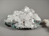 two pieces of white crystals sitting on top of a table