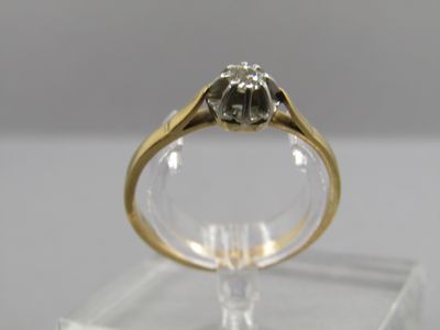 un gros plan d'une bague en diamant posée sur un socle transparent