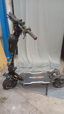 un scooter posé par terre devant une toile de fond