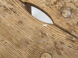 a close up of a wooden bench with holes in it