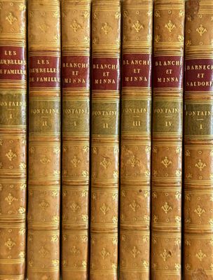 several old books are lined up on a shelf in a library