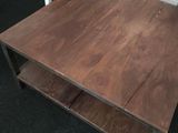 a wooden table with a shelf on it in a room
