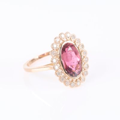 a close up of a pink tourmaline and diamond ring on a white background