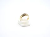 un gros plan d'une bague posée sur un support, sur une surface blanche