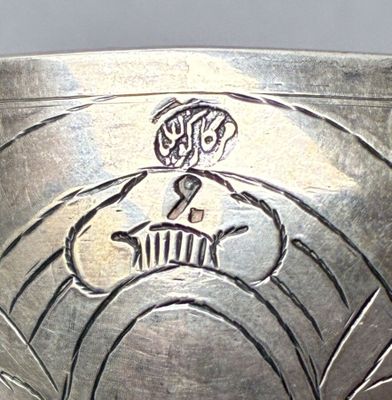 a close up of a silver bowl with a design on it