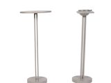 pair of metal pedestals with a round table top and a round base