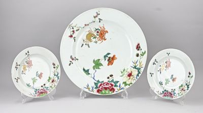 trois assiettes et un bol décorés de fleurs, posés sur une table