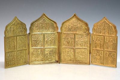 trois portes métalliques dorées ornées de sculptures sur un fond blanc