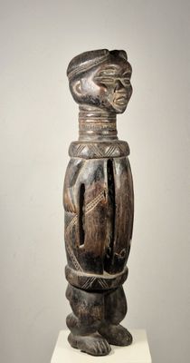 une image représentant une sculpture en bois représentant une personne portant un chapeau